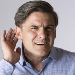 Studio Shot Of Man Suffering From Deafness
