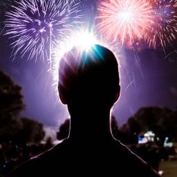 Silhouette of a person watching fireworks